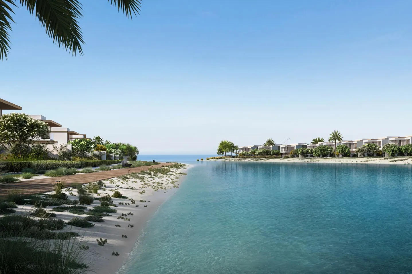 Calm canal with a sandy edge and boardwalk beside villas