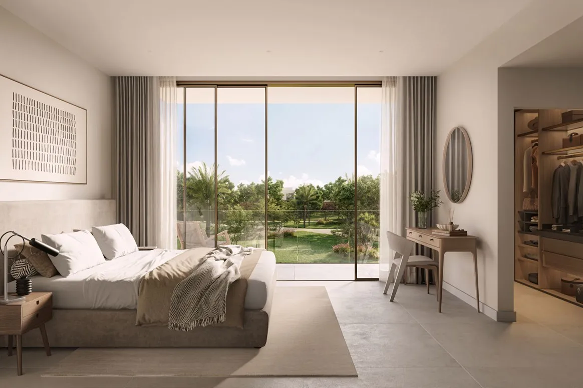 Bedroom with walk-in wardrobe and glass doors to a garden view